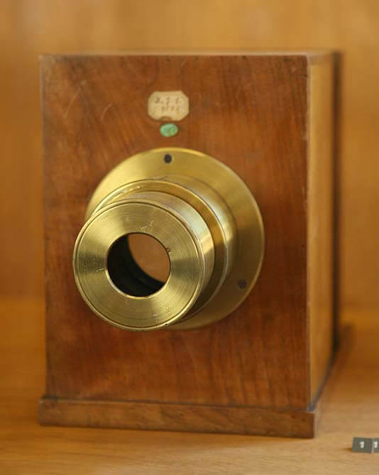 An old brown daguerreotype camera made of wood.